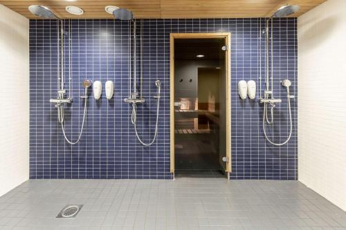 许温凯斯堪迪克赫维嘎酒店的蓝色瓷砖浴室设有2个淋浴间
