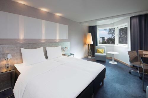 斯塔万格Scandic Royal Stavanger的卧室配有一张白色大床和一张书桌