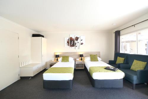 北哈夫洛克北哈夫洛克汽车旅馆 的一间设有两张床和蓝色沙发的房间