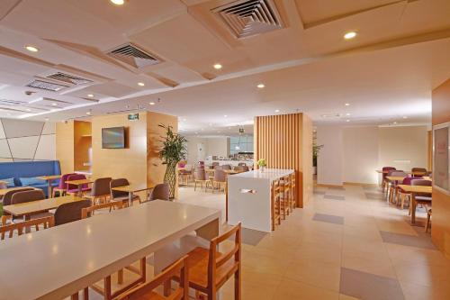 唐山唐山中心智选假日酒店的一个带桌椅的大堂和一间自助餐厅