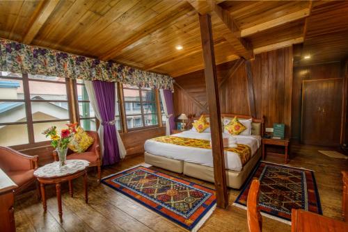 大吉岭Muscatel Himalayan Resort - 400 Mts from Mall Road的一间卧室配有一张床、一张沙发和一张桌子