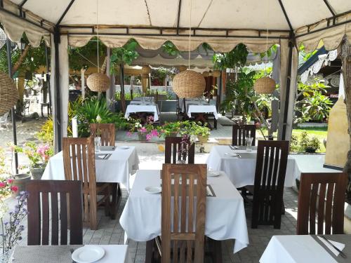 乌纳瓦图纳别墅酒店 的帐篷下设有白色桌椅的餐厅