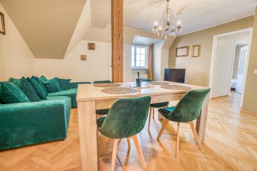 塔林Historic Residence Apartments at Old Town的客厅配有绿色沙发和桌子