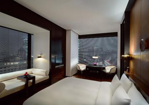 上海上海璞丽酒店的一间卧室配有一张床、一张书桌和一个窗户。