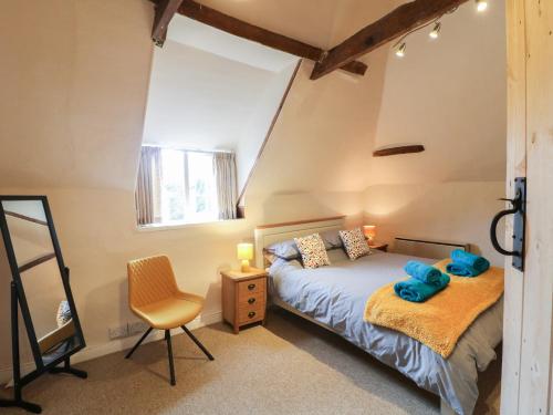 格兰瑟姆Kings Cottage的一间卧室配有一张床和一把椅子
