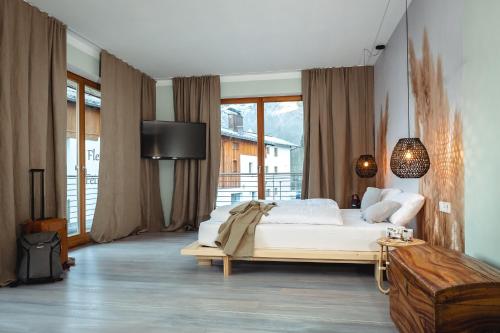 罗孚尔Der Steinerwirt - hangout & hotel的卧室设有一张白色大床和大窗户