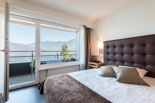 贝肯里德泽拉什瑞士优质酒店的一间卧室设有一张床和一个大窗户