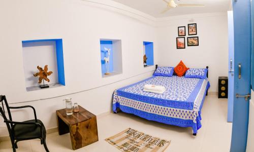 焦特布尔Aura B&B - The Haveli Homestay的一间蓝色和白色的卧室,配有一张床和一张桌子