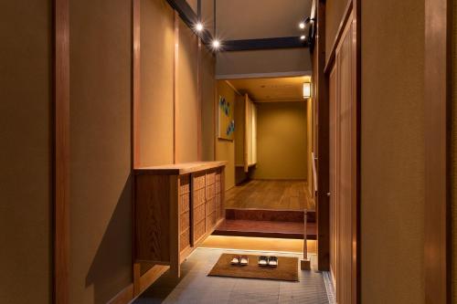 京都祇園の宿 杏花的走廊上设有带步入式淋浴间的浴室