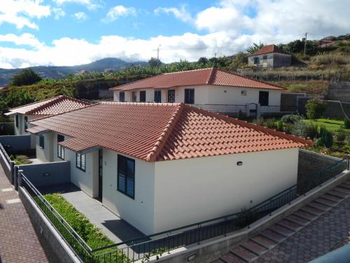 圣克鲁斯Villas Madalena Chalets vista mar cWiFi的白色房子,有红色的瓦屋顶