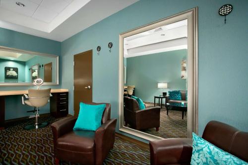 格林帕克Aviator Hotel & Suites South I-55, BW Signature Collection的客厅配有镜子、椅子和书桌