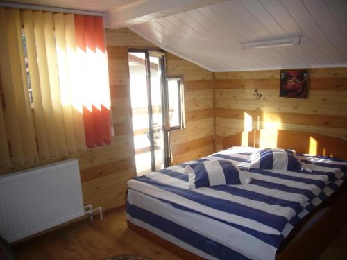 锡纳亚Complex Vile Daniel的卧室配有一张床铺,位于带木墙的房间内