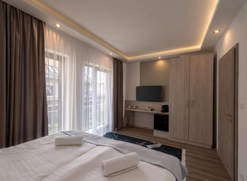 佩奇Fibula Residence Hotel & Wellness - Adults Only的一间卧室配有一张带两条白色毛巾的床