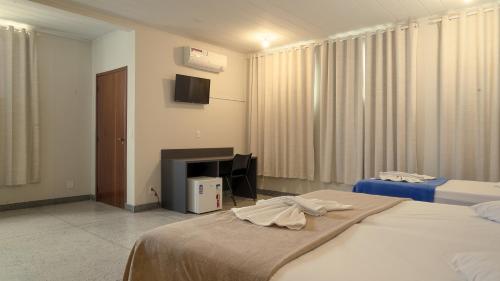 阿拉沙Hotel Araxá的酒店客房设有两张床和电视。
