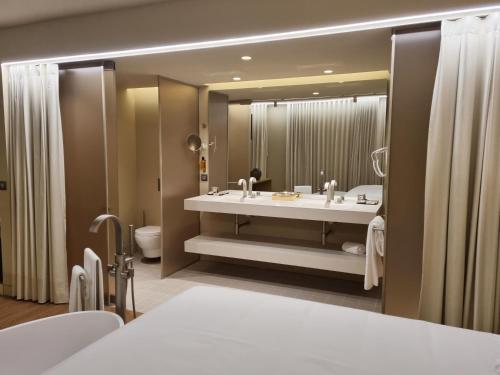 英雄港Zenite Boutique Hotel & SPA的一间带水槽和大镜子的浴室