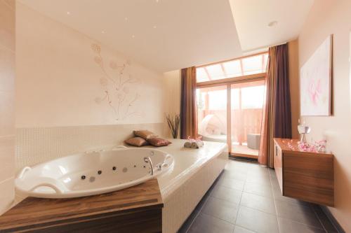 兹雷切兹瑞克温泉 - 艾特酒店的一间大浴室,内设一个大浴缸