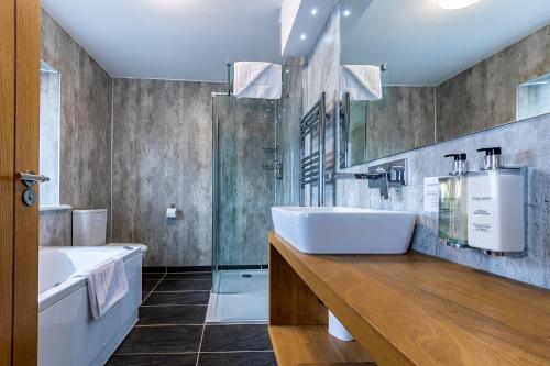 韦尔斯十字路口酒店的一间带水槽、浴缸和淋浴的浴室