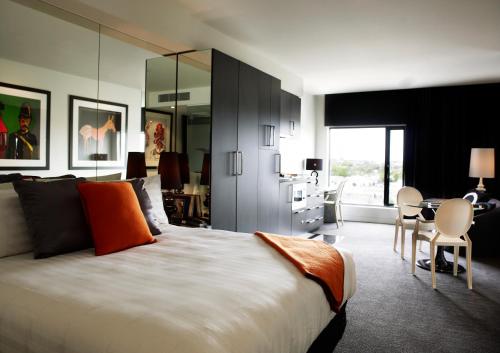 墨尔本艺术系列酒店 - 卡伦的一间卧室配有一张大床和一张桌子及椅子