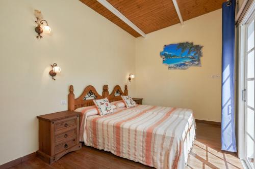 布埃纳维斯塔德尔诺尔特2 bedrooms house with shared pool enclosed garden and wifi at Buenavista del Norte 1 km away from the beach的一间卧室配有一张床和一个木制梳妆台