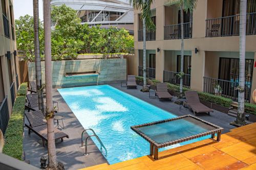 莱卡邦素万那普村舍酒店的一座带椅子的室外游泳池和一座建筑