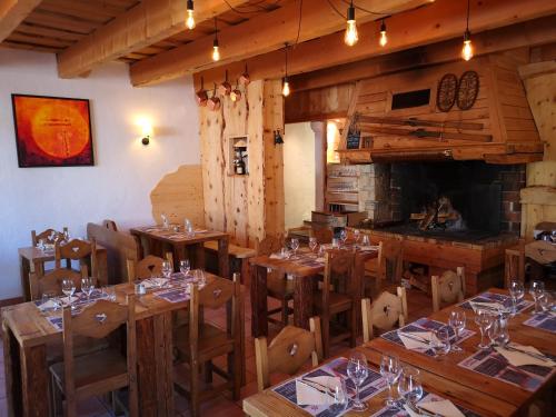 韦尔科尔地区科尔朗松奥博格曼彻罗勒斯酒店的餐厅设有木桌、椅子和壁炉