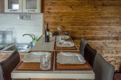 大特尔诺沃Guest house Viki的餐桌,配有一瓶葡萄酒和玻璃杯