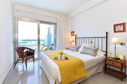 莫甘海滩Luxury BeachFront Mogan的一间卧室设有一张大床和一个大窗户