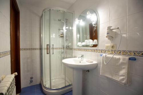 坎加斯-德奥尼斯卡瑟纳卡酒店的一间带玻璃淋浴和水槽的浴室