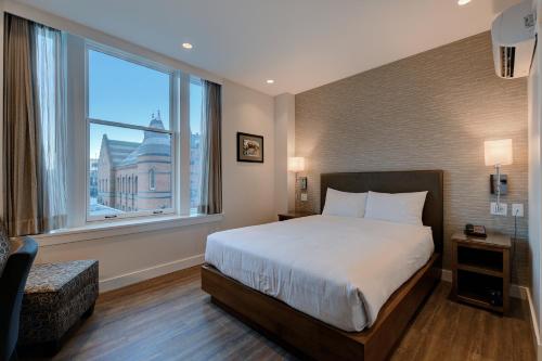 维多利亚斯特拉斯科酒店的一间卧室设有一张床和一个大窗户