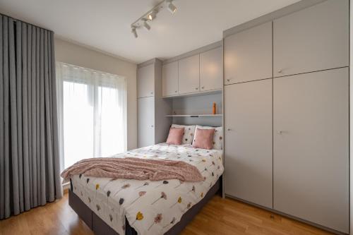克诺克－海斯特Meerzicht-Laguna的一间卧室配有床和白色的大橱柜