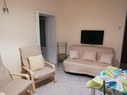里奥马里纳Casa Milena的客厅配有沙发、电视和椅子