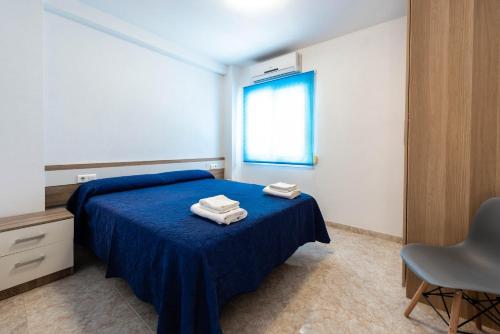 内尔哈EDIFICIO CHAPARIL的一间卧室配有蓝色的床和2条毛巾