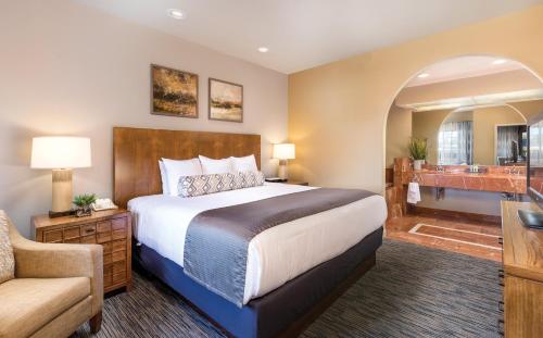 凤凰城莱格斯高尔夫度假酒店的一间卧室配有一张床和一把椅子,还有一间浴室