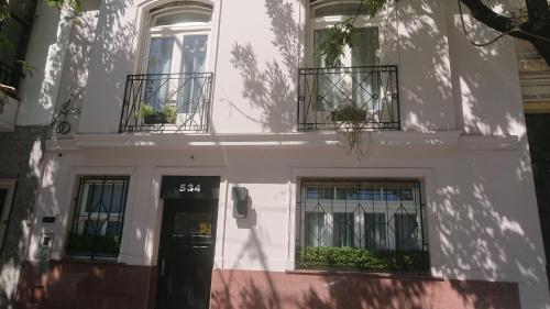 布宜诺斯艾利斯534 Petit San Telmo - Studio & Suites的白色的建筑,设有两个阳台和门