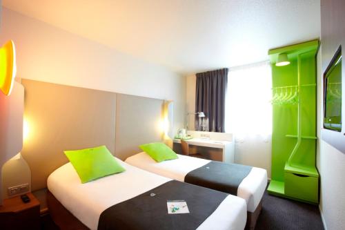 庞坦钟楼巴黎东潘定酒店的酒店客房设有两张绿色床铺。