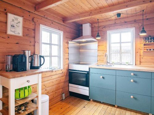 阿森斯4 person holiday home in Assens的小木屋内的厨房配有蓝色橱柜