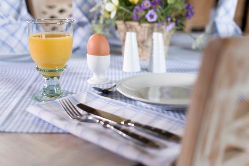 沃利茨Gasthaus und Pension "Zum Hauenden Schwein"的一张桌子,上面放着鸡蛋和一杯橙汁