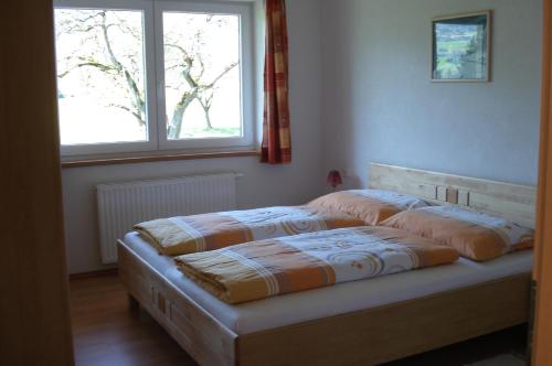 奥贝朴菲斯Ferienwohnungen Simon - Hauserhof的卧室内的一张床铺,带窗户