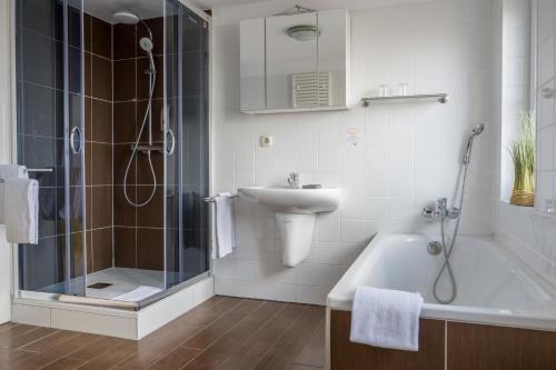 威廉港AKZENT Strandhotels Seestern, Delphin & Lachs的带淋浴、盥洗盆和浴缸的浴室