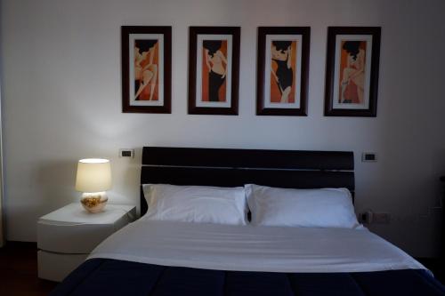 蒙特西尔瓦诺Appartamento Residence Acquarius的卧室配有一张四幅画的墙壁床。