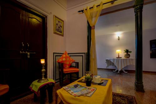 斋浦尔The Umaid Vilas Royal Heritage Haveli的客厅配有一张带黄桌布的桌子