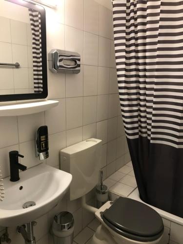 杜塞尔多夫可欧酒店的浴室配有卫生间、盥洗盆和淋浴。
