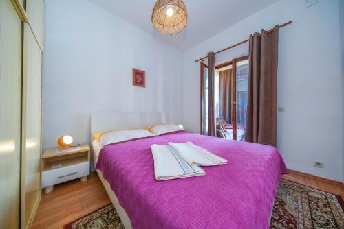 索布拉Apartments Filipović的一间卧室配有一张紫色床和毛巾
