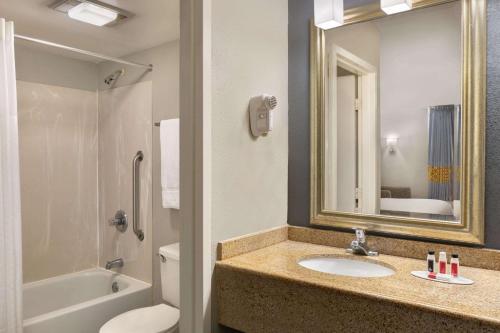 威尔明顿Baymont by Wyndham Wilmington的一间带水槽、卫生间和镜子的浴室