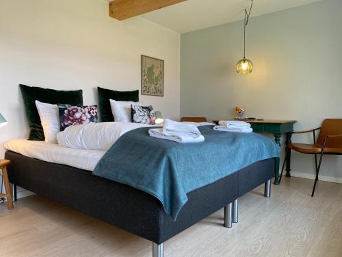 森讷堡Rønhave的一间卧室配有一张大床和毛巾