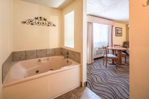 科达伦科达伦品质酒店和套房的一个带桌子的房间的大浴缸