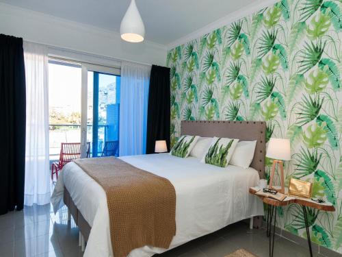 莫甘海滩Amazónico Playa de Mogán的一间卧室配有一张带热带壁纸的床