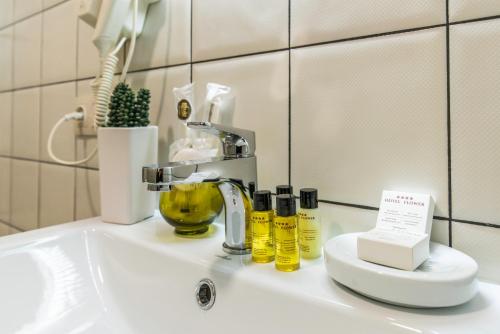 第比利斯Hotel Flower的浴室水槽配有水龙头和瓶子