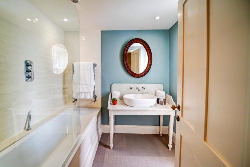 Newbiggin高力酒店的一间带水槽、浴缸和镜子的浴室