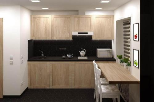塔什干ART STUDIO 3的厨房配有木制橱柜和带微波炉的桌子。